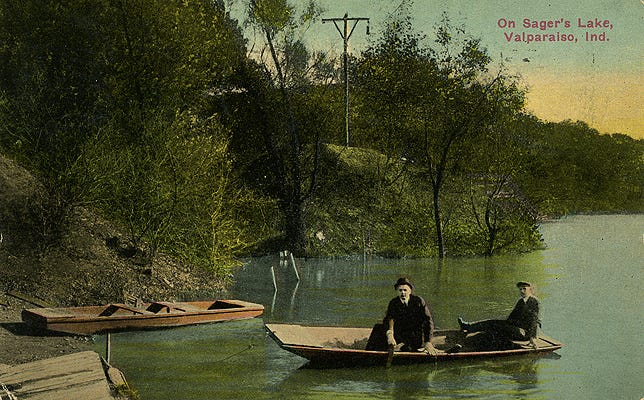 A postcard featuring two men on a boat on Sager's Lake
