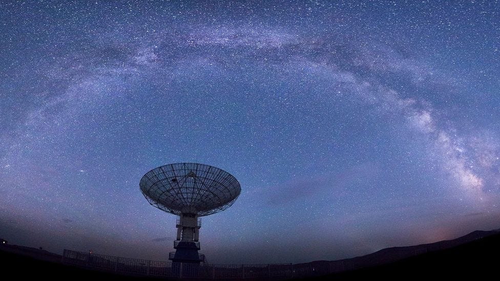 Arc of stars above radio dish antennae (Credit: Honglouwawa/Getty Images)