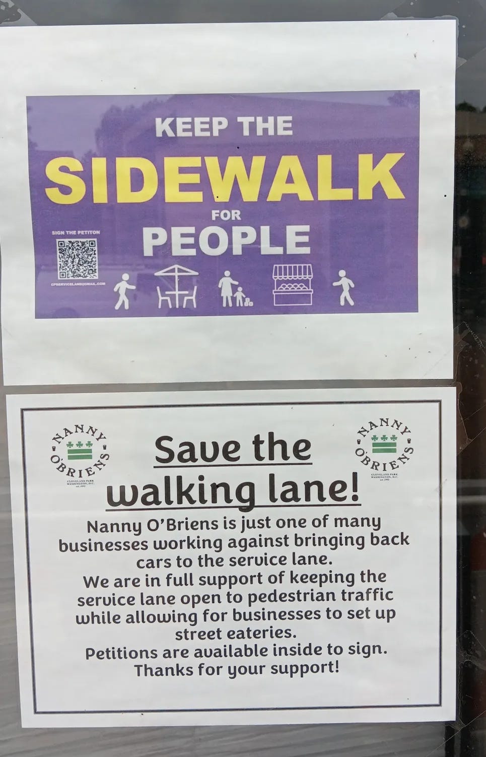 Signs posted on the storefront saying "keep the walking lane" and "keep the sidewalk for poeple"