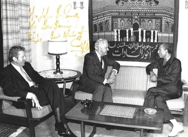 From left, Mr. Barnes, Mr. Connally, and President Anwar el-Sadat of Egypt in a black and white photograph, which has yellow writing on it.