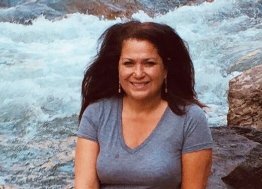 Blanca Kumbera, a registered nurse, sits beside a river. She passed away in August 2024.