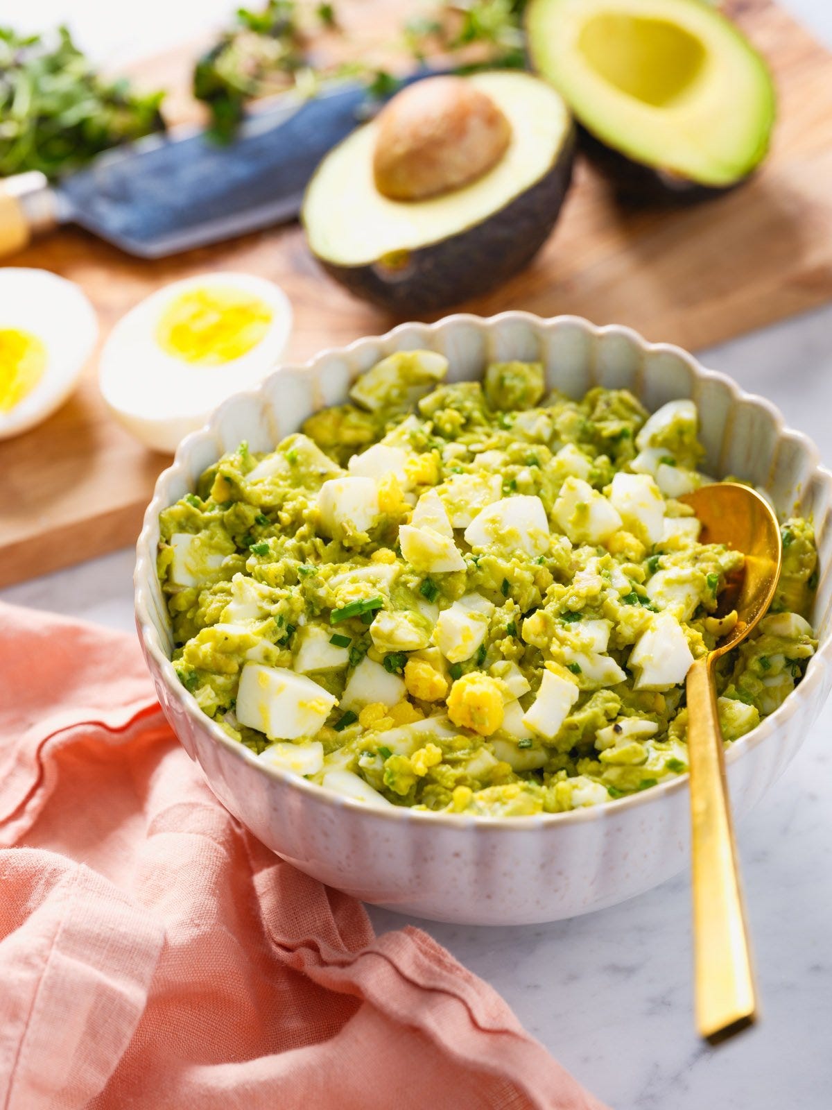 Avocado egg salad in a bowl with spoon.