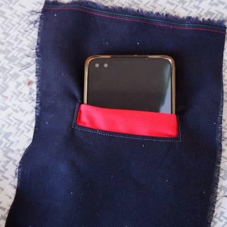 A welt pocket with a contrasting welt and a phone peeking out from the pocket