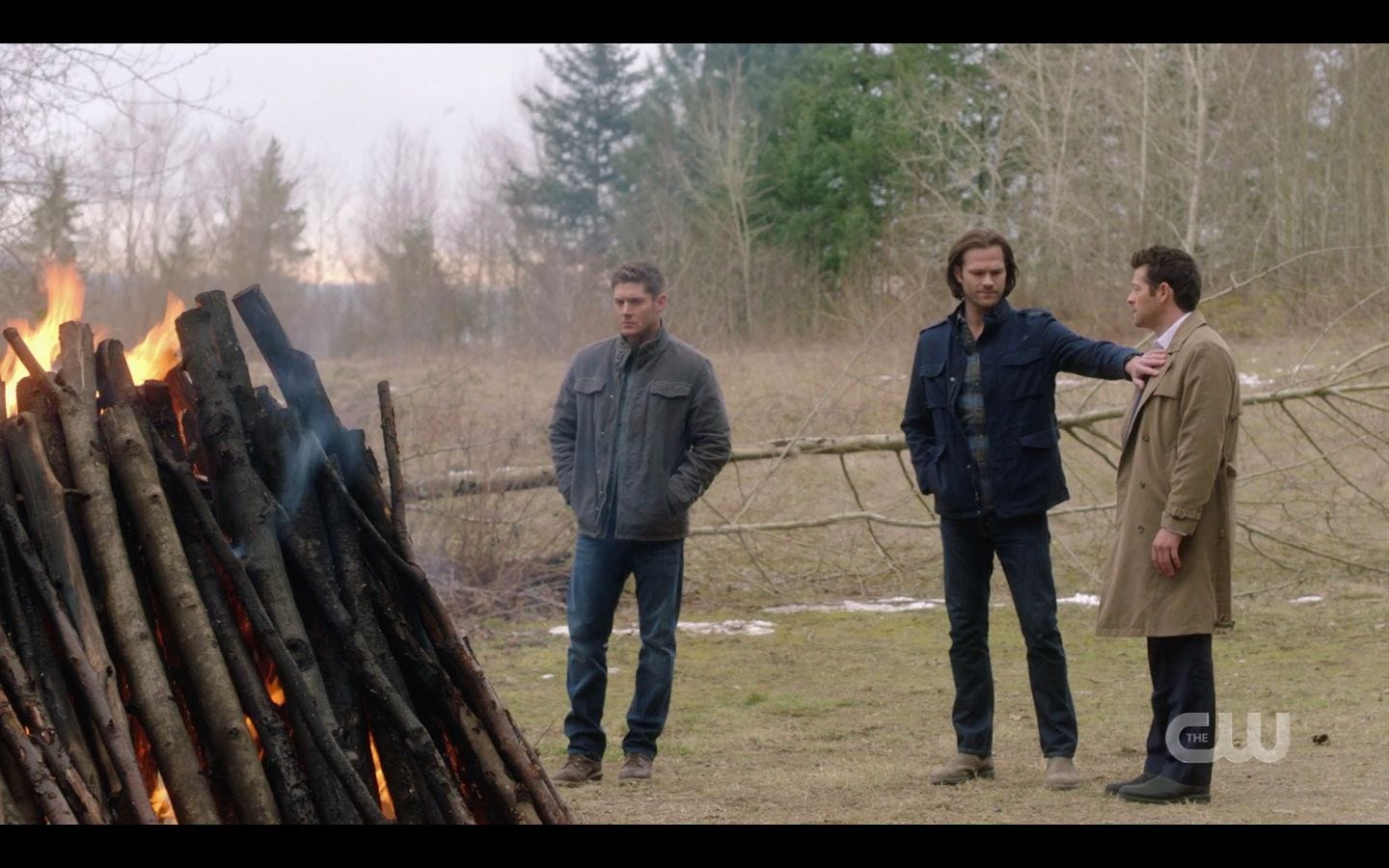 Castiel tries to go to him to offer comfort, but Sam Winchester puts out a hand and stops him, shaking his head as fire burns.