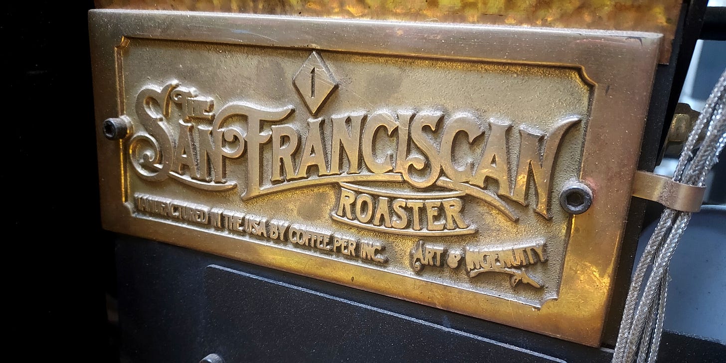 Close up of a gold plate with The San Franciscan Roaster Company logo. Close-up affixed to the side of a roasting machine.