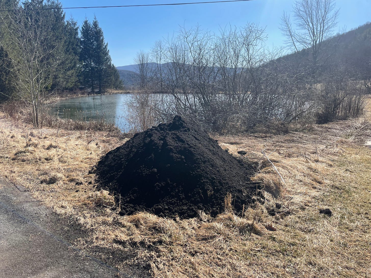 beautiful pile of compost pile with a frozen lake and mountain behind