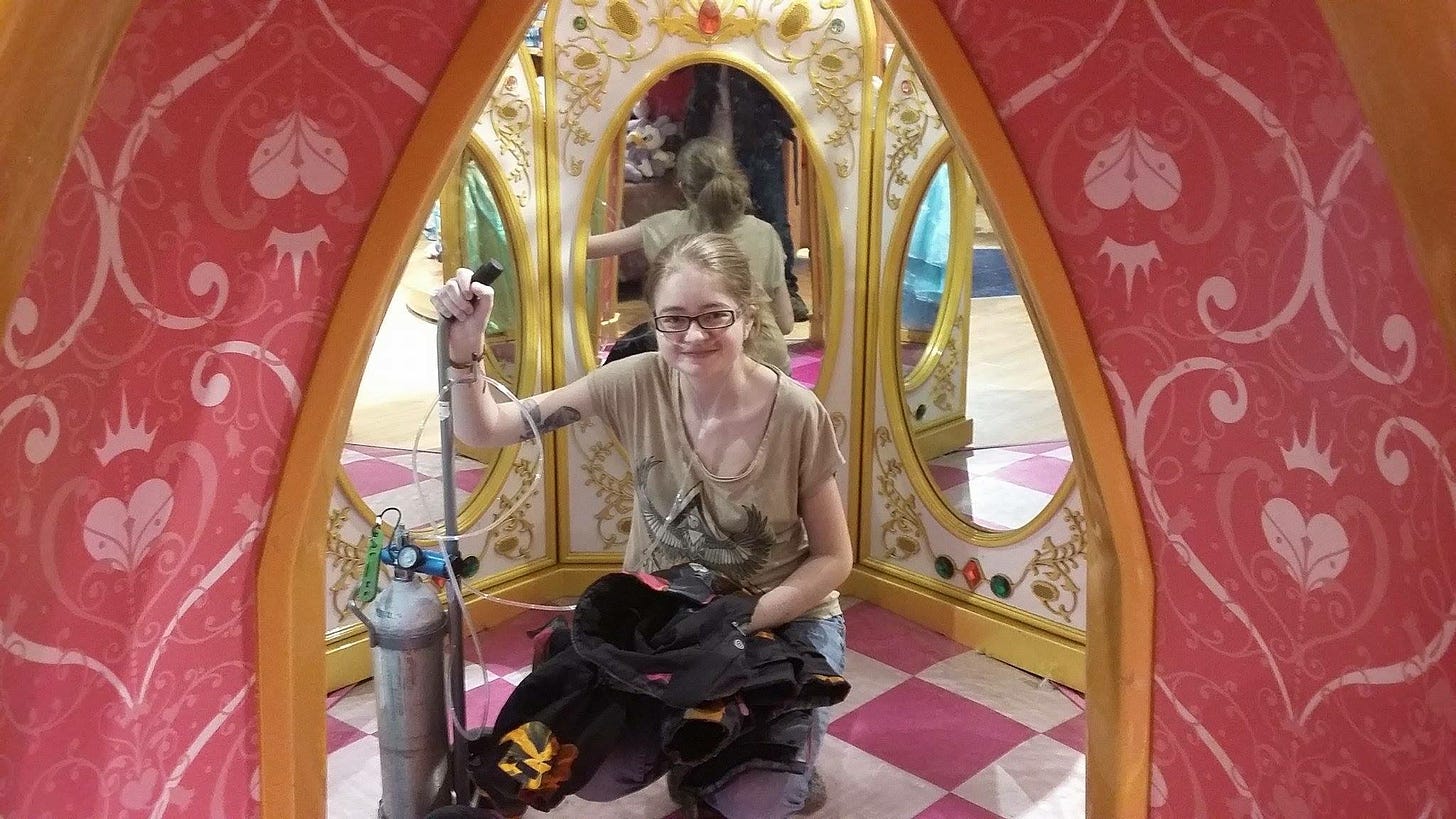 A photo of me with oxygen prongs and an oxygen tank in the Disney store.