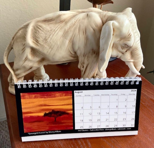Calendar with Serengity scene on an end table with an elephant sculpture in situ.