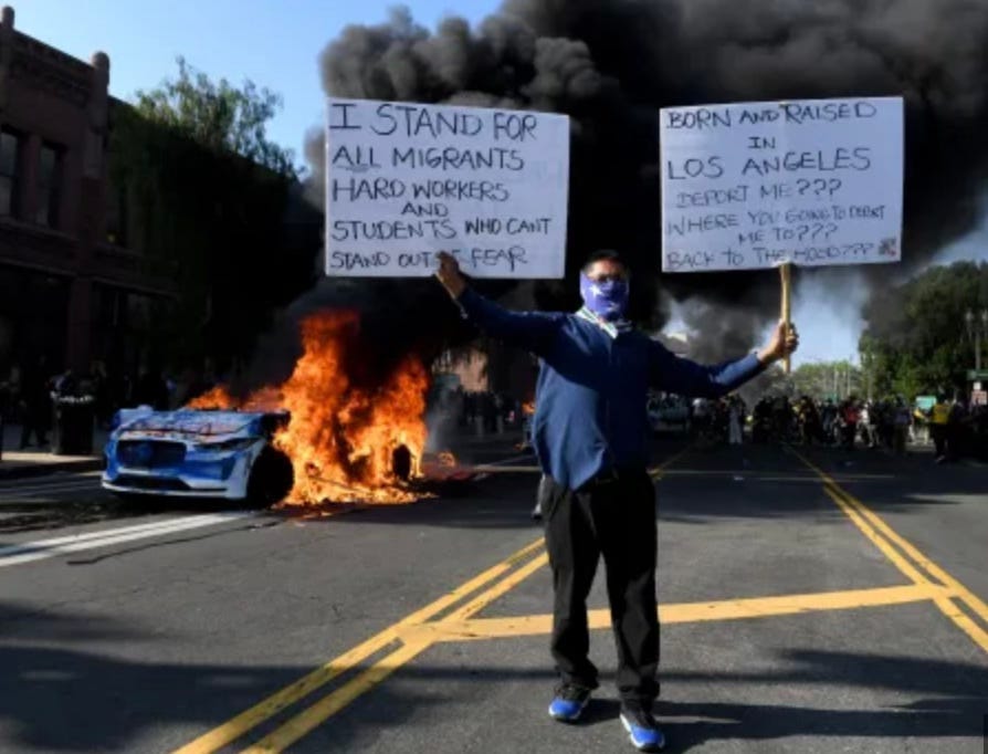 A protester in Los Angeles, holding placards in support of immigration.