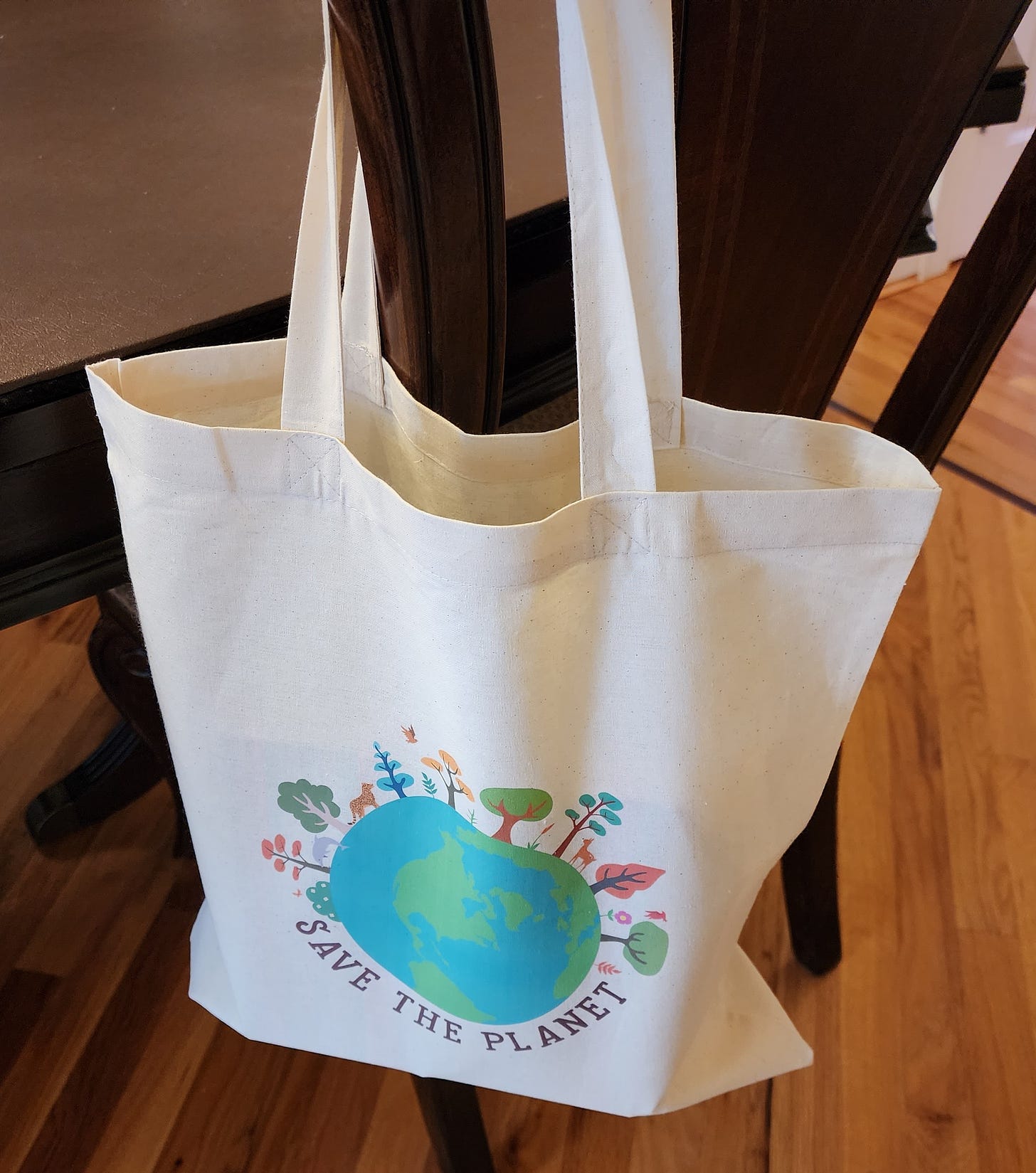 Save The Planet tote bag hanging on chair