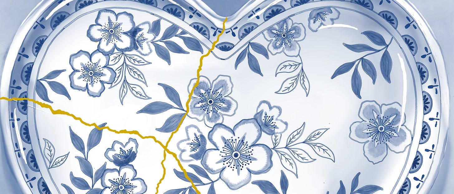 Detail view of a delicate, heart-shaped porcelain bowl, hand-painted with soft cherry blossoms, leaves and fine blue stems. The bowl is visibly cracked and lovingly repaired using shimmering gold leaf, inspired by the art of Kintsugi. Set against a gentle, blue background, the piece evokes the beauty of renewal, blooming, and healing, a celebration of springtime and emotional rebirth.