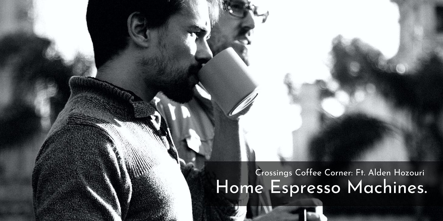 A black and white photo of two men in profile looking outward sipping on mugs of coffee. The man closer to the camera wears a half-collared henley shirt, has dark hair and a burgeoning scruff of a beard. His coffee mug is plain white.