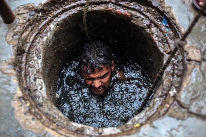 Joney is a 26 year-old sewer worker in Ghaziabad India, July 26, 2018. These workers clean the sewers by going inside the pits without any safety equipment besides a safety belt used to lift them up and out. .