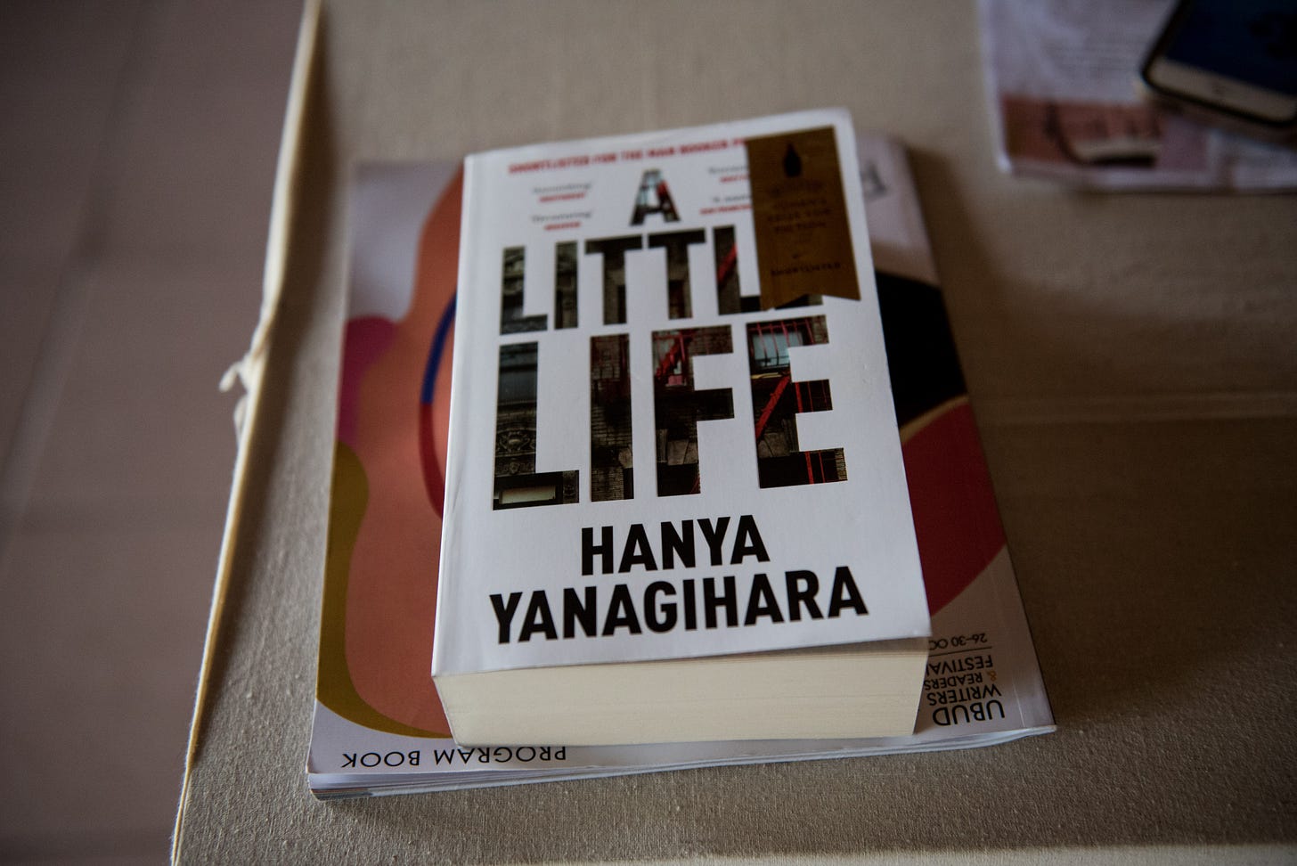 The book "A Little Life" by Hanya Yanagihara pictured lying on top of a magazine
