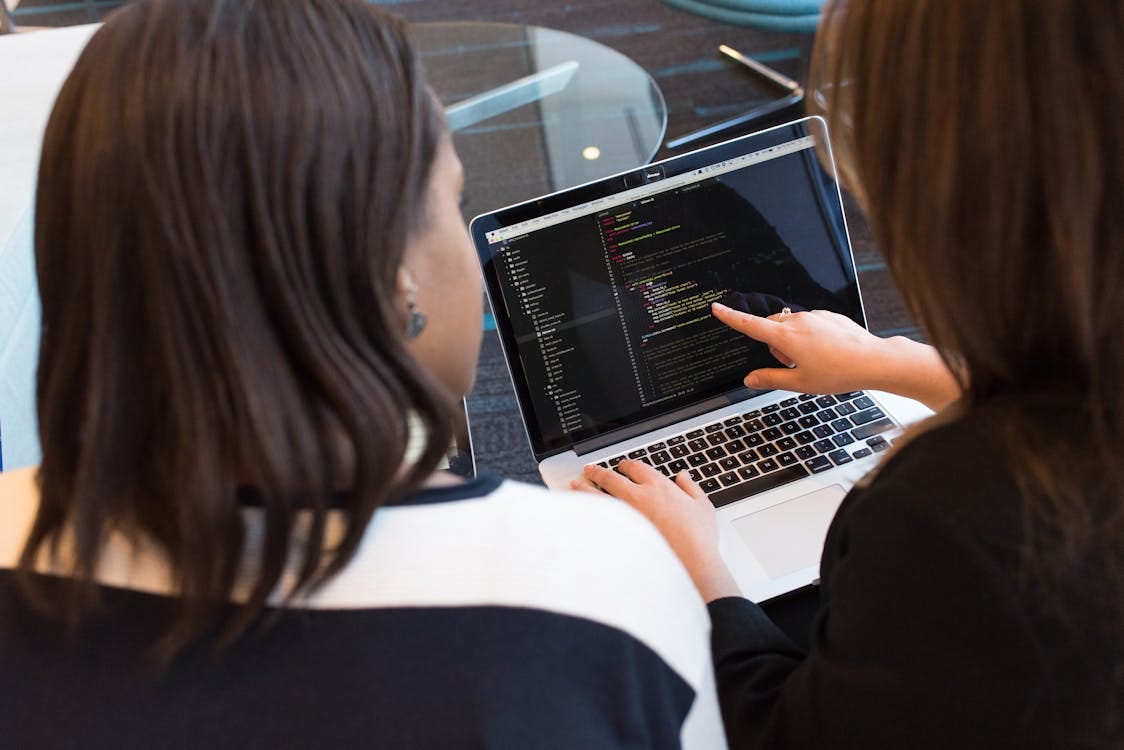 grátis Duas Mulheres Olhando Para O Código No Laptop Foto profissional