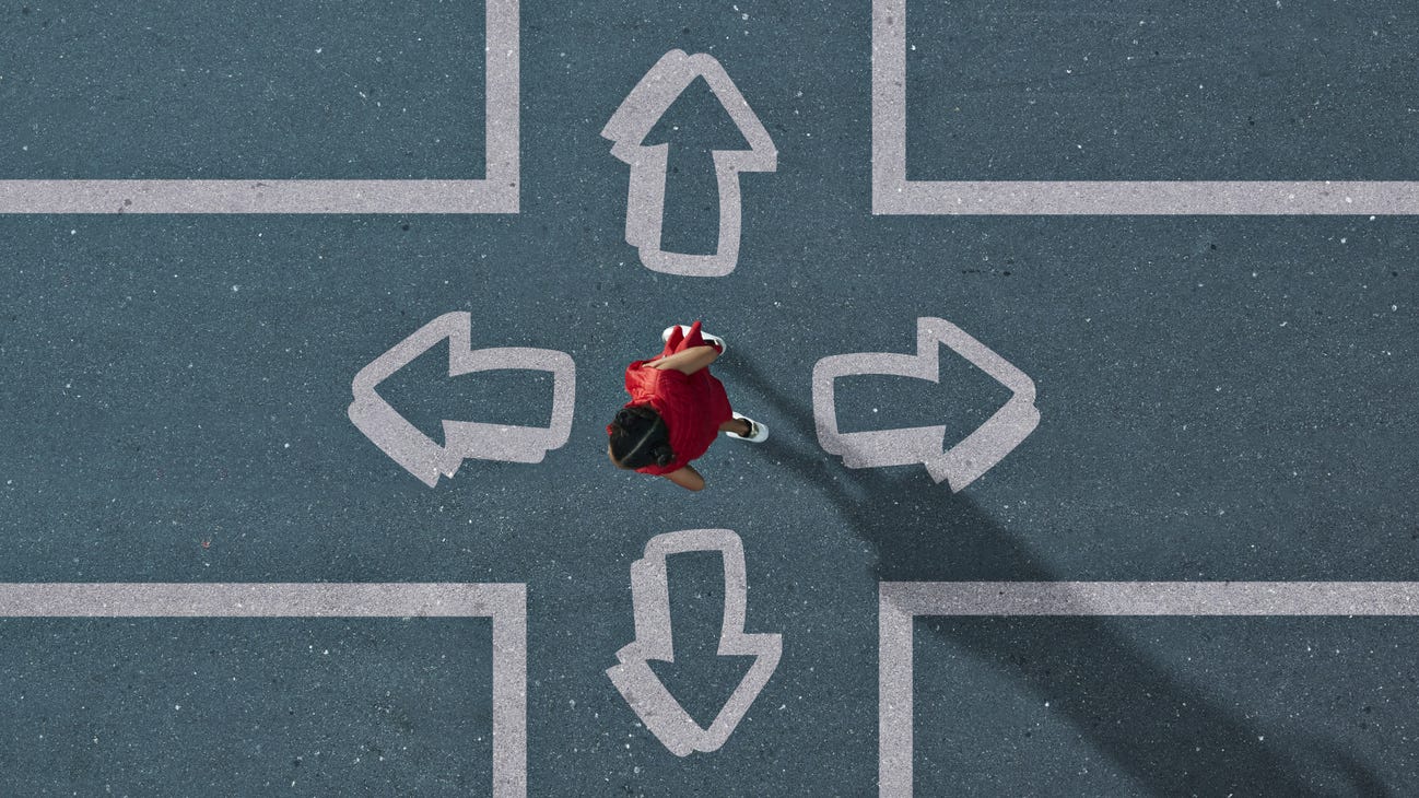 A person in red at a 4-way intersection, deciding where to go.