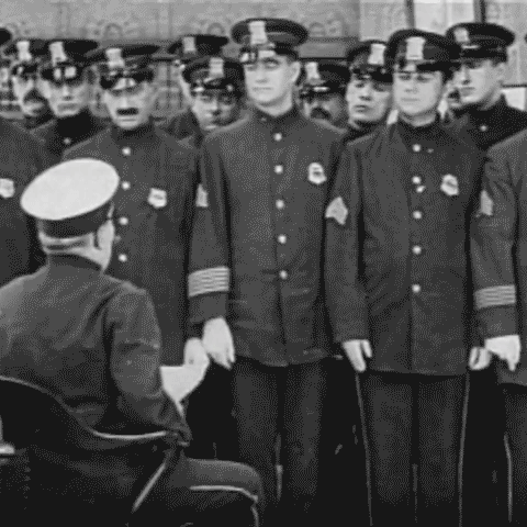 Animated gif of police officers saluting from 1913 film Traffic in Souls