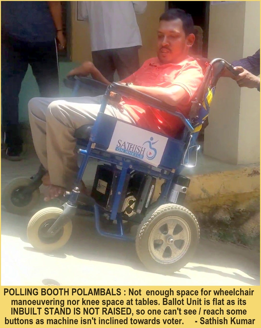 Sathish, an Indian man in a red T-shirt is sitting on his wheelchair with someone pushing it because the ramp is steep.The text at the bottom of the photo reads: Polling booth Polambals: Not enough space for wheelchair manoeuvring not knee space at tables. Ballot unit is flat as its inbuilt stand is not raised, so one can’t see/reach some buttons as machine isn’t inclined towards voter - Sathish Kumar.