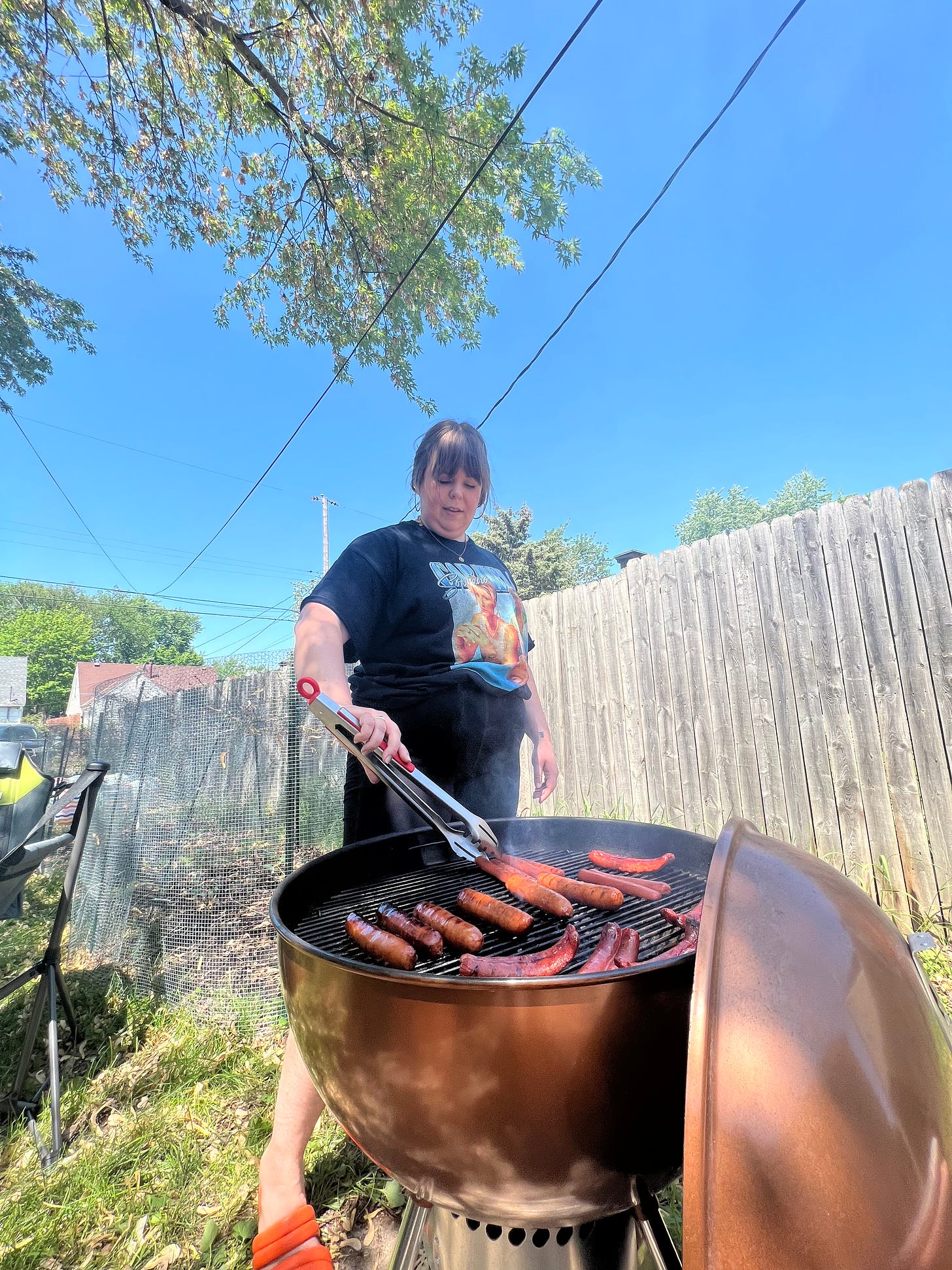 photo of Melissa flipping brats and hotdogs on the grill