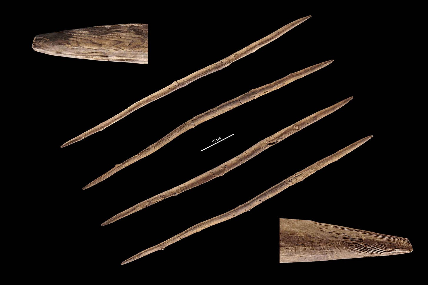 Four views of a double-pointed throwing stick in center, with detail of sharpened points at top left and bottom right. Four views of a double-pointed throwing stick in center, with detail of sharpened points at top left and bottom right.