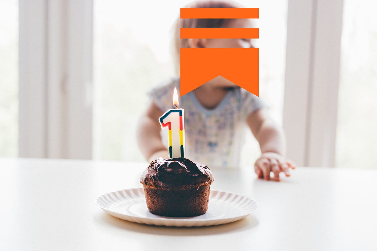a baby in front of a chocolate cupcake with a number one candle on it. the baby's face has a substack logo over it.