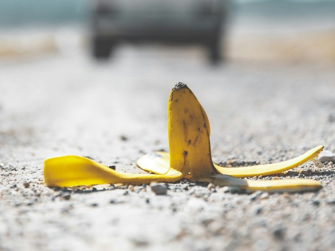 yellow banana peel on white sand during daytime