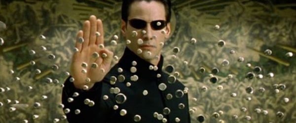 Cena do filme Matrix em que o personagem Neo - Interpretado por Keanu Reeves - consegue parar uma rajada de balas no ar.