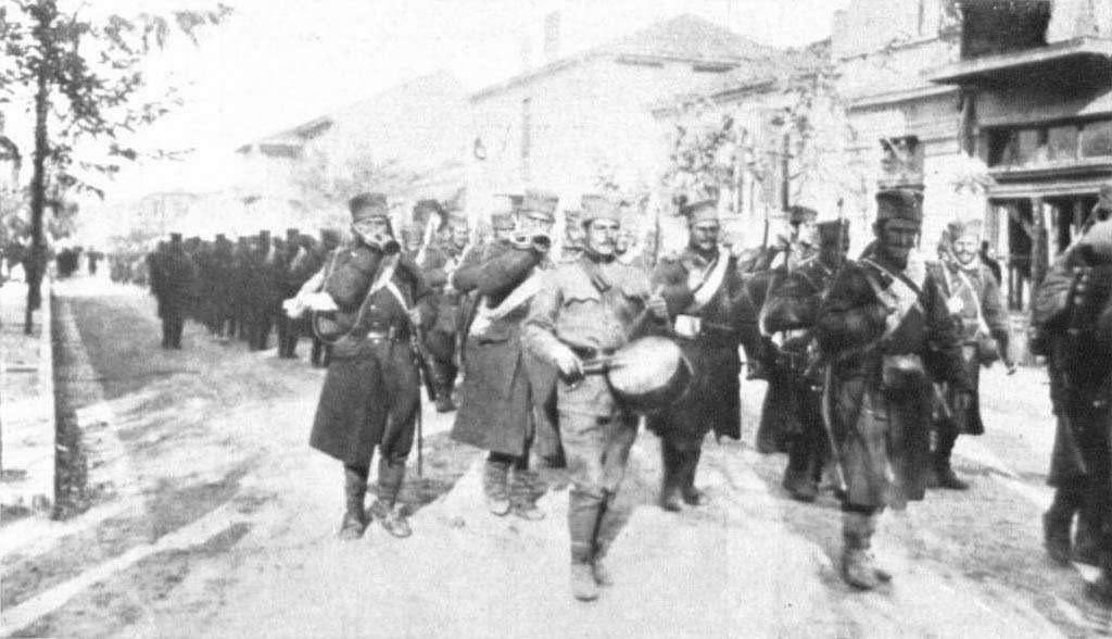 A photo showing Freshly mobilised Serbian soldiers marching to the borders. The columns extends back. A drummer marches proudly near the front.