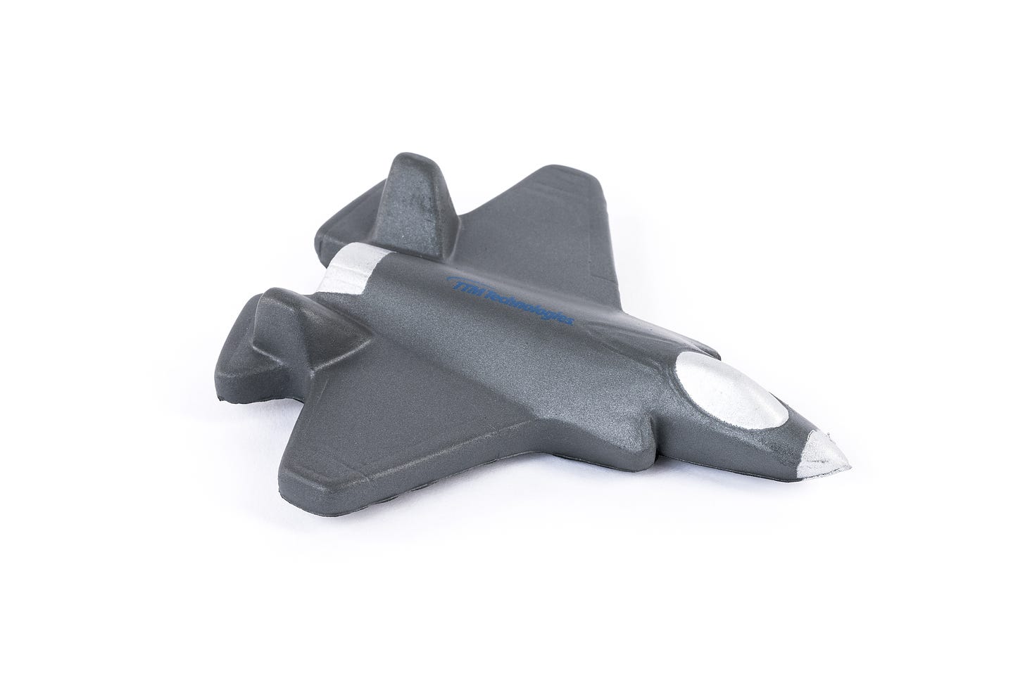 Picture of a small squashy toy against a white background. The toy represents a grey fighter jet.