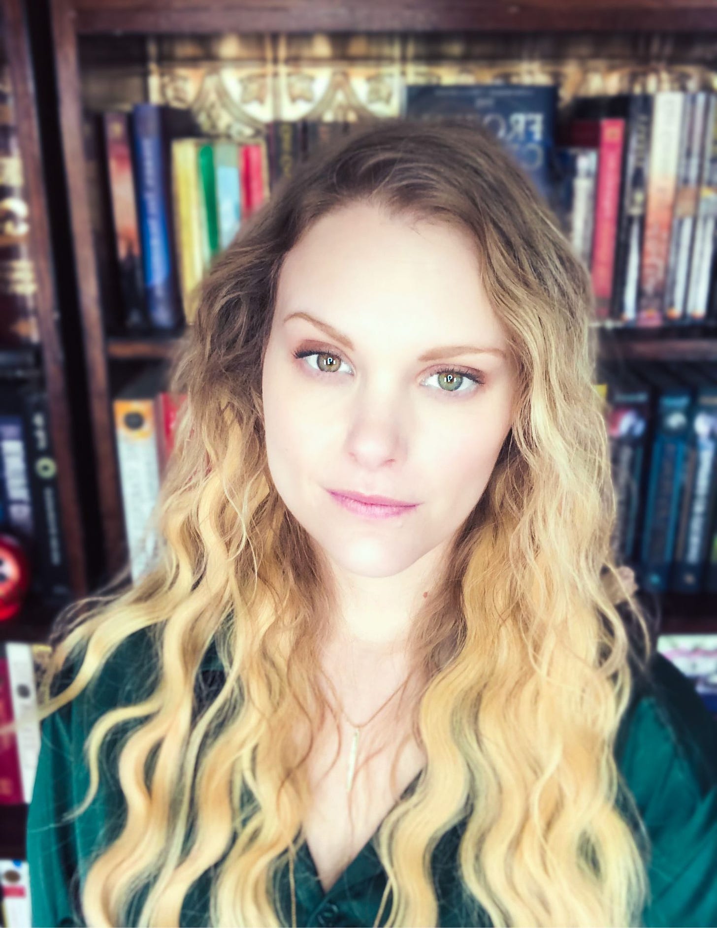 A picture of a white woman with blonde hair and a green shirt.