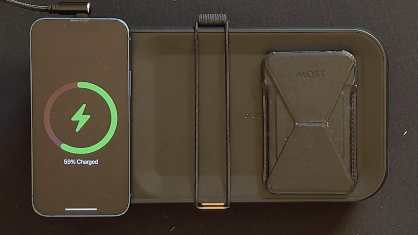 The lid of the Nest v2 showing off the small valet section for keys and a wallet. It also shows an iPhone charging using the built in Qi charger