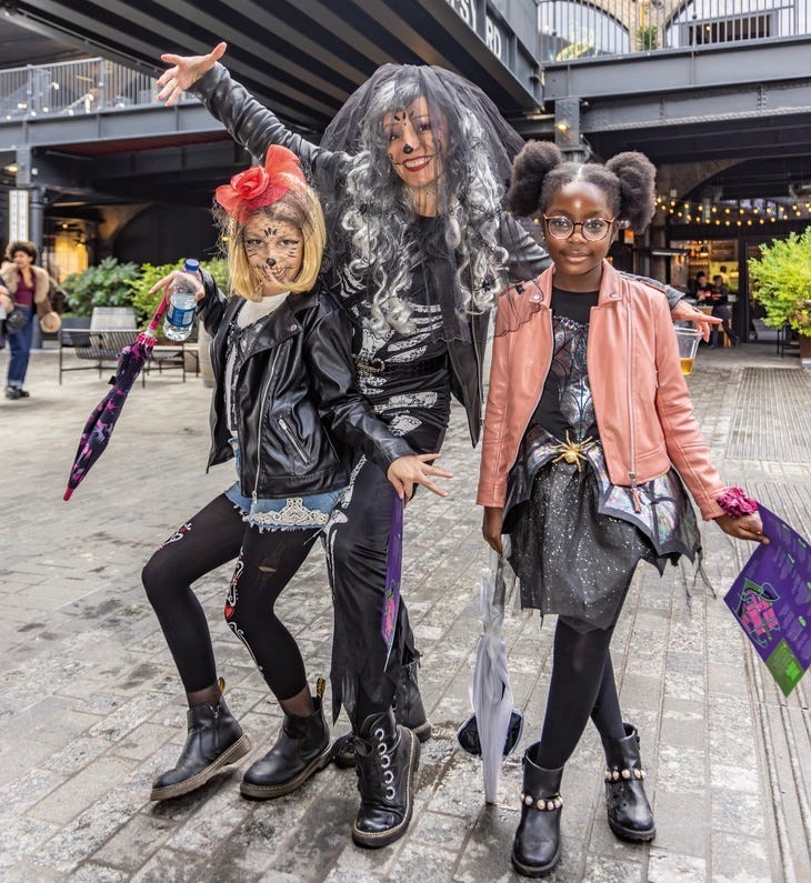 An adult and two kids dressed in Halloween getup