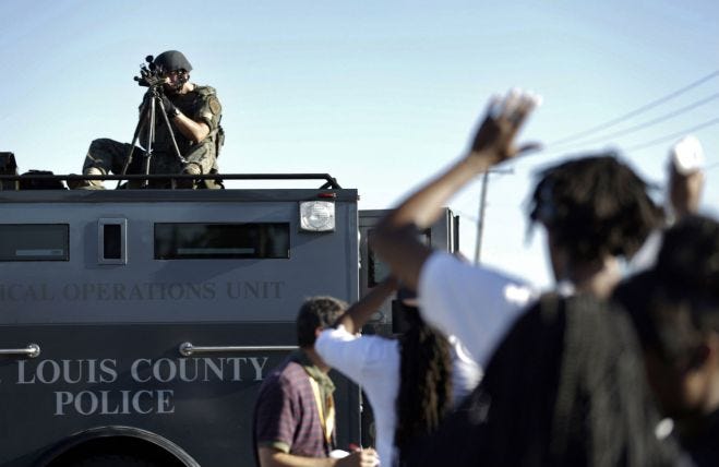 ferguson_police_military sniper pointing at crowd