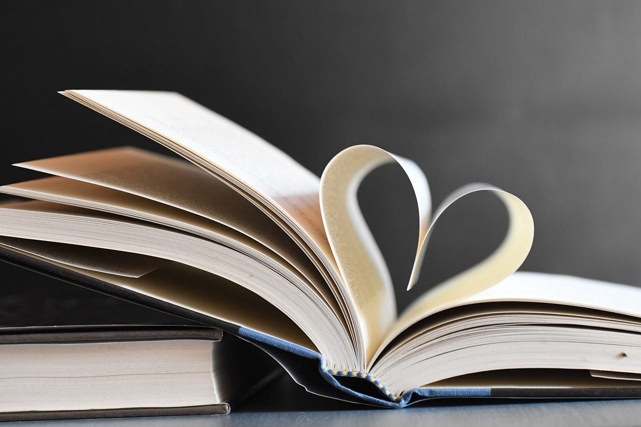 an open book with a page folded into a heart symbol