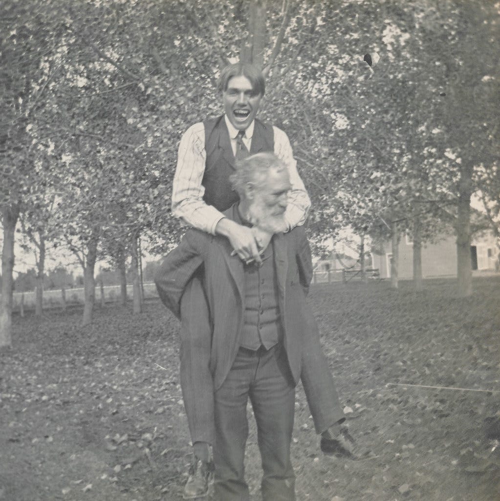 Young man rides piggyback on an old man