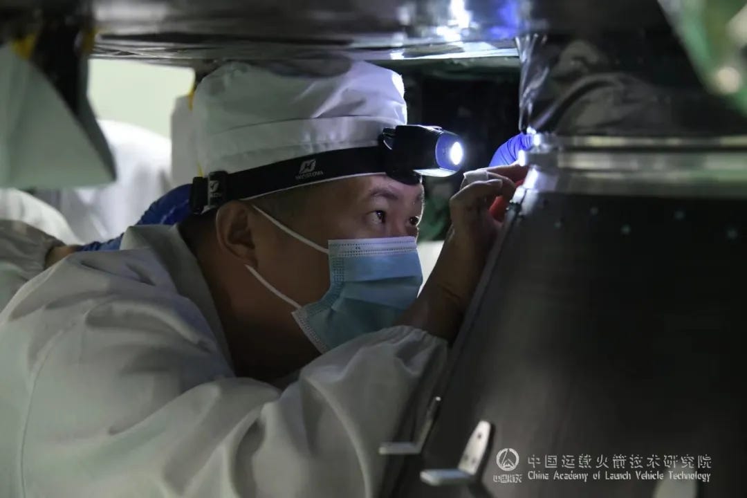 A worker ensuring that the WHG-03 satellite is firmly attached to the Long March 3B/E Y99 vehicle’s payload adapter ahead of encapsulation.