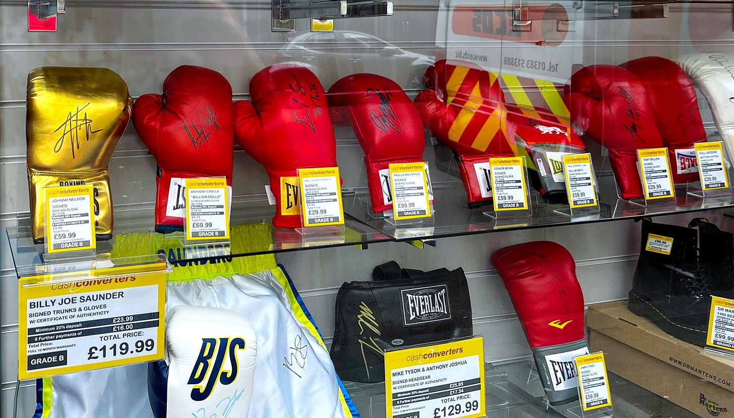 a shelf of red, autographed boxing glvoves --priced with installement plans