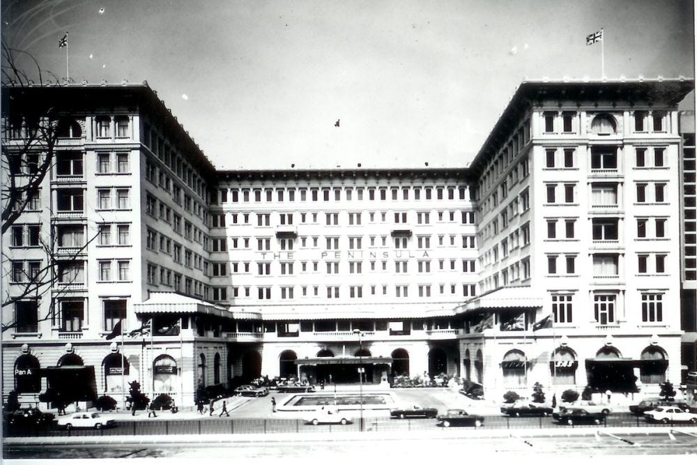 Foto in bianco e nero dell'hotel Peninsula: facciata in stile coloniale, con pareti bianche e finestre ordinate