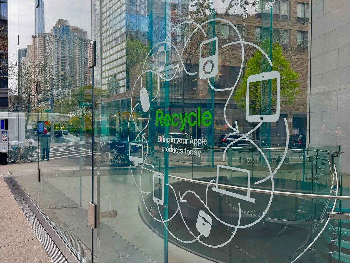 A vinyl decal on the windows of Apple Upper West Side. The decal says, "Recycle – Bring in your Apple products today."