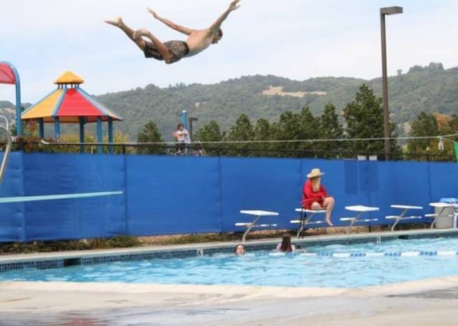 young man diving into pool looks like flying