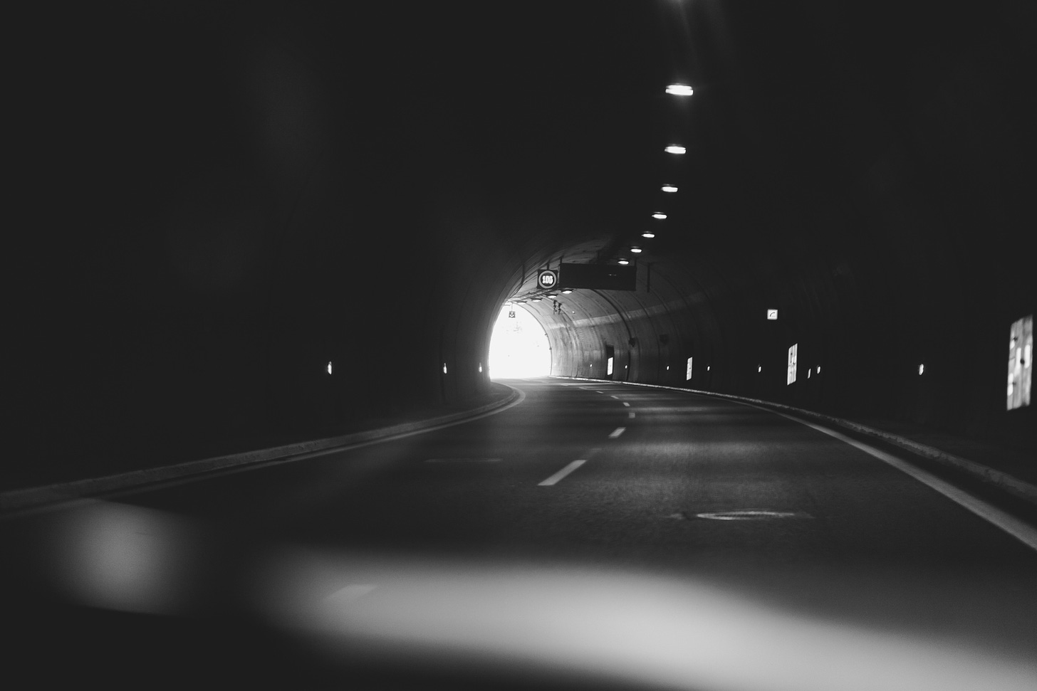 strada dentro un tunnel in bianco e nero, sullo sfondo si vede la luce dell'uscita