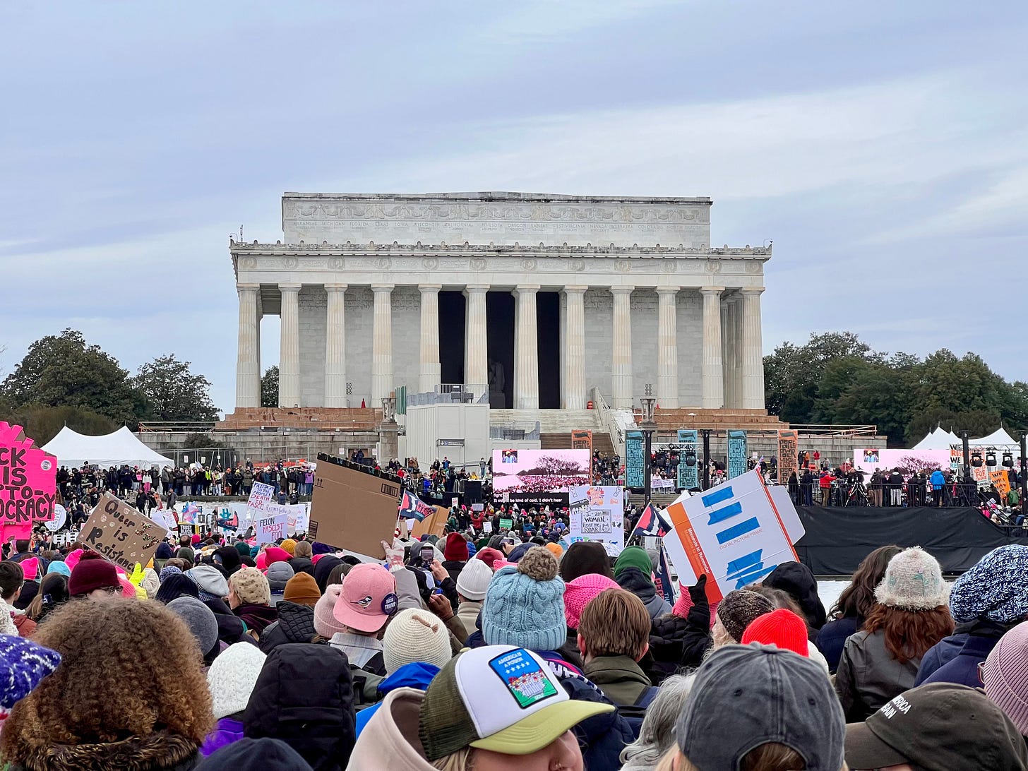 a crowd gathered in Washington, DC, lifting protest signs.