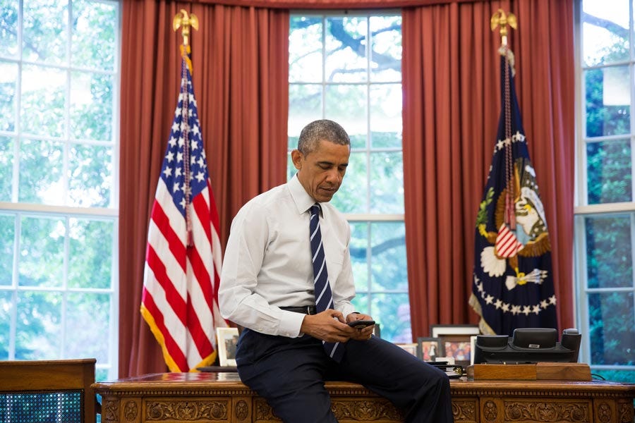 This image shows a 31 October 2016 photo of an unjacketed President Barack Obama sitting on the front edge of the Oval Office's Resolute Desk while scrolling his smartphone's screen. This photo was staged for the Obama White House's "Digital Transition" webpage. This image shows a 31 October 2016 photo of an unjacketed President Barack Obama sitting on the front edge of the Oval Office's Resolute Desk while scrolling his smartphone's screen. This photo was staged for the Obama White House's "Digital Transition" webpage.