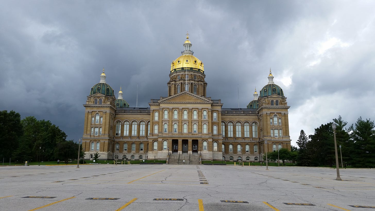 Iowa Capitol building with shining golden dome sits before dark clouds. The parking lot, which is visible in the foreground, is empty. Iowa Capitol building with shining golden dome sits before dark clouds. The parking lot, which is visible in the foreground, is empty.