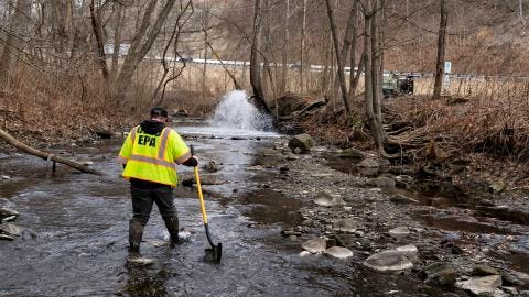 Ron Fodo with Ohio EPA Emergency Response checks for chemicals that might have settled at the bottom of Leslie Run Creek on Monday.
