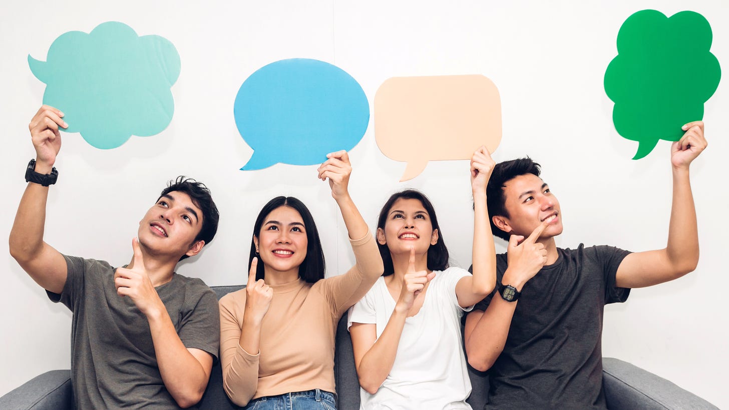 Four young people holding colorful speech bubbles and looking up thoughtfully.