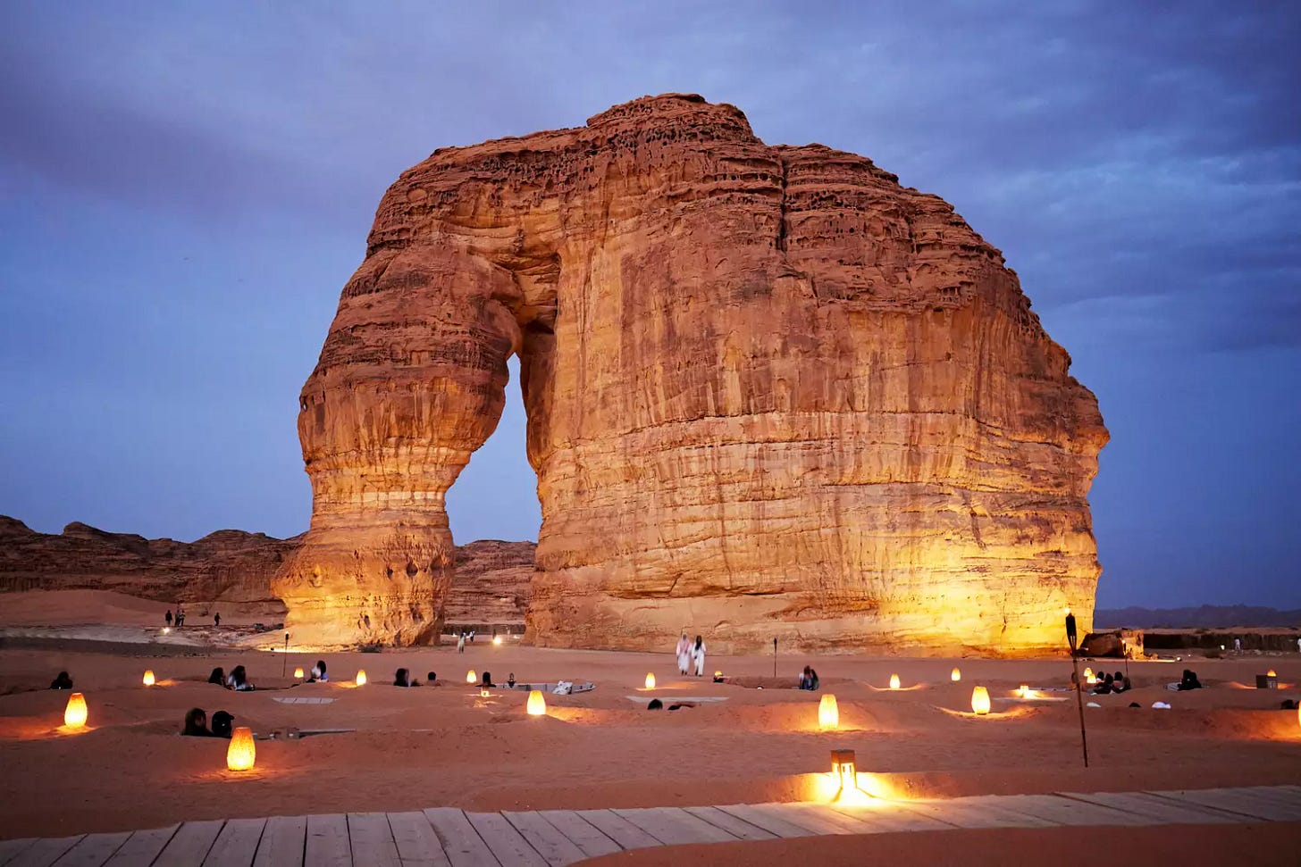 Full view of illuminated red sandstone monolith also known as Jabal Alfil, shaped for millions of years by wind and rain.