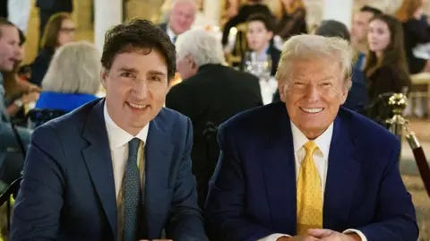 Justin Trudeau/X Justin Trudeau and Donald Trump, both in blue suits, sit shoulder to shoulder with people seen in a crowd behind them 