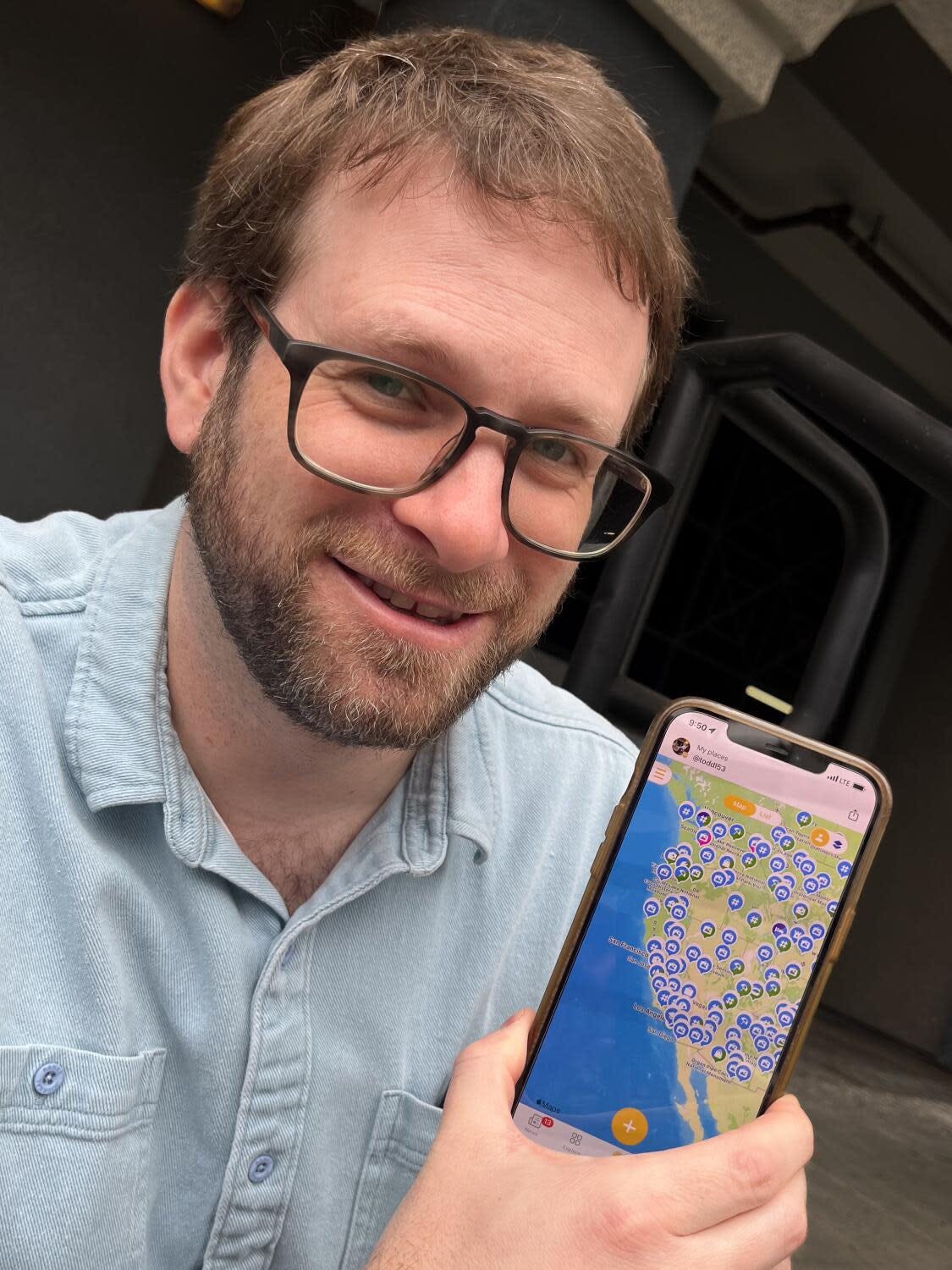 Todd Lerew holds up a cellphone that is displaying a map of Southern California.