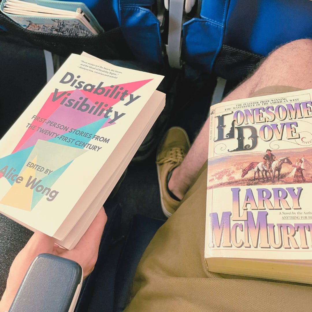 A photograph of two books on two laps: Disability Visibility, and Lonesome Dove.